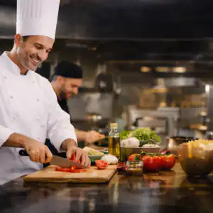 Operatore di cucina professionale che prepara ingredienti in una cucina professionale durante la preparazione di piatti